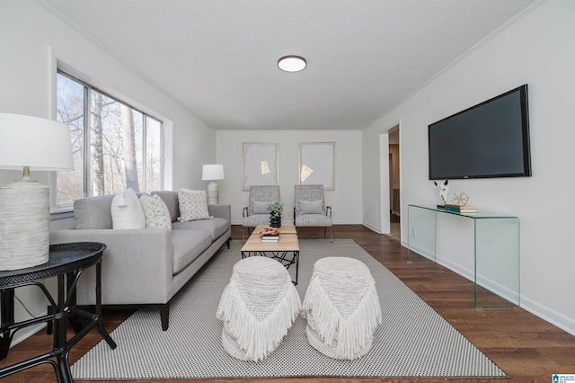 living room featuring crown molding, dark wood-type flooring, and a textured ceiling