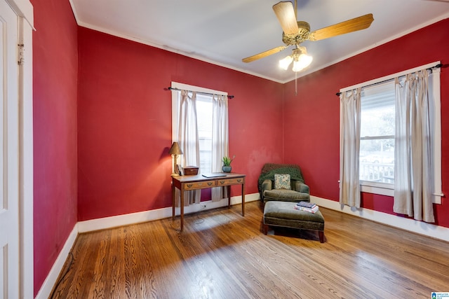 sitting room featuring hardwood / wood-style floors, crown molding, a healthy amount of sunlight, and ceiling fan