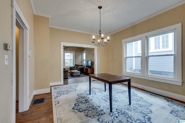 dining space with an inviting chandelier, hardwood / wood-style floors, and ornamental molding