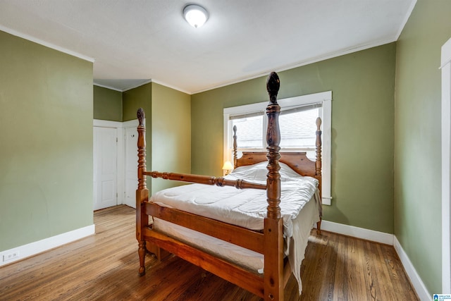 bedroom featuring ornamental molding and wood-type flooring