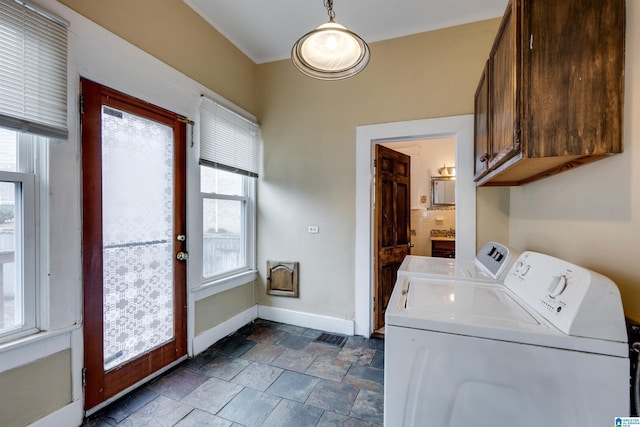 clothes washing area with cabinets, ornamental molding, and separate washer and dryer