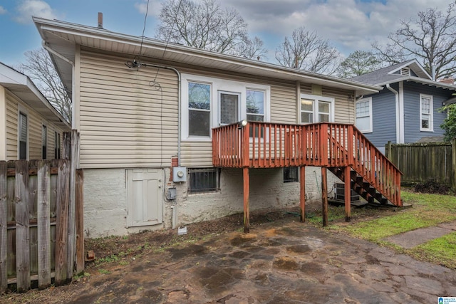 back of property featuring a wooden deck and a patio