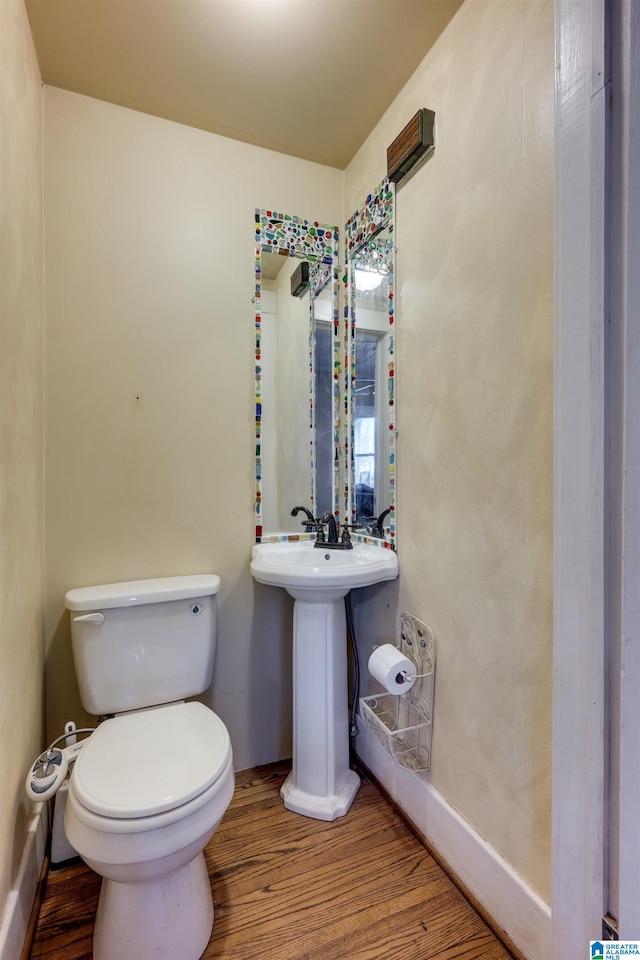 bathroom featuring wood-type flooring, sink, and toilet