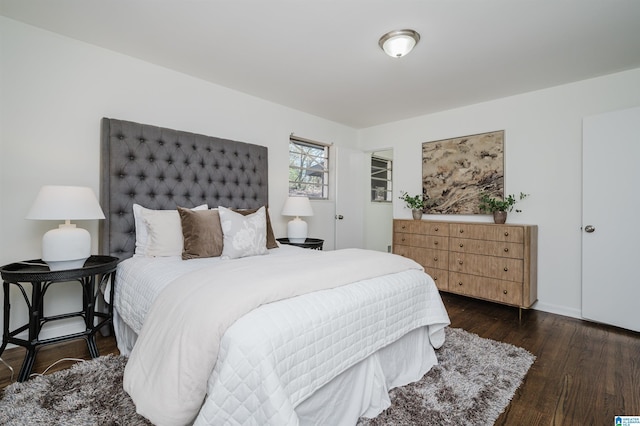 bedroom with dark hardwood / wood-style flooring