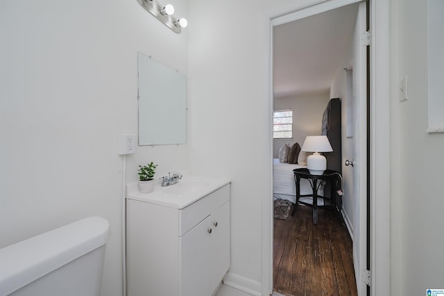 bathroom featuring wood-type flooring, toilet, and vanity