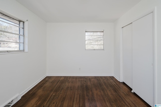 unfurnished bedroom featuring dark hardwood / wood-style flooring and a closet