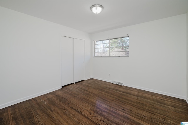 spare room featuring dark wood-type flooring