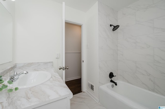 bathroom with tiled shower / bath combo and vanity