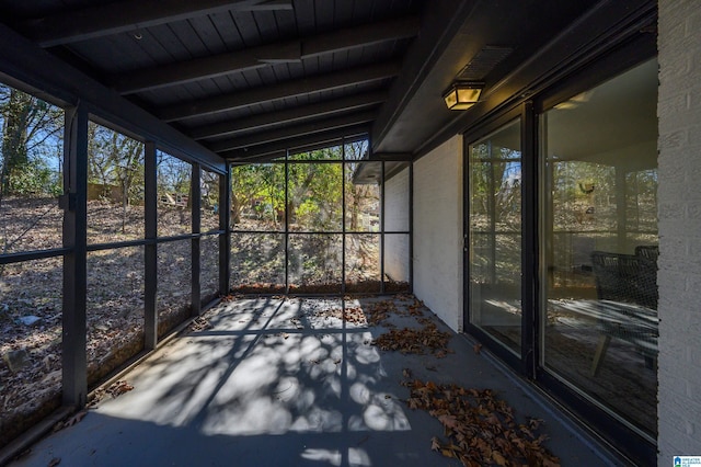 unfurnished sunroom with vaulted ceiling with beams