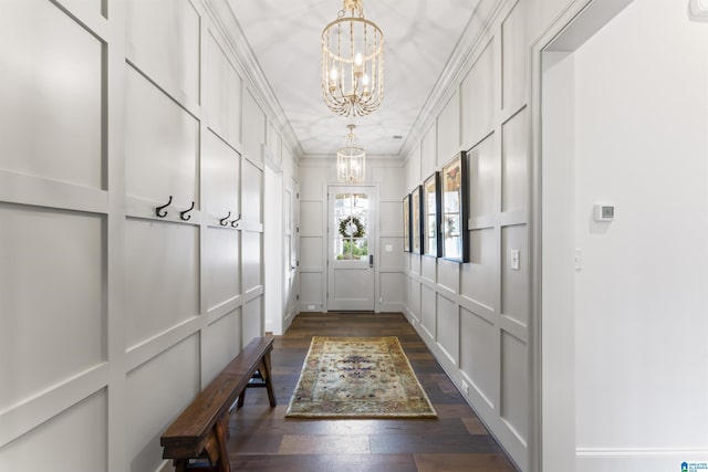 doorway featuring dark wood-type flooring, ornamental molding, and a notable chandelier