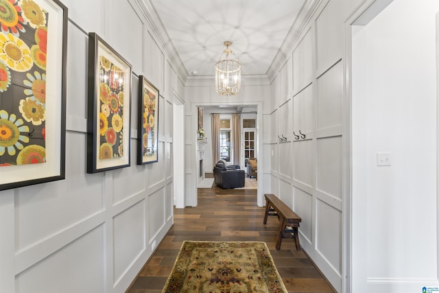 hallway featuring ornamental molding, a notable chandelier, and dark hardwood / wood-style flooring