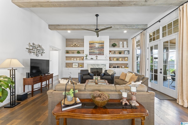 living room with built in shelves, hardwood / wood-style floors, beam ceiling, and french doors