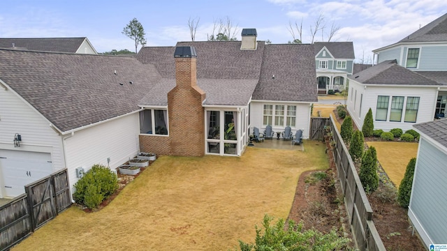 back of house with a patio and a lawn