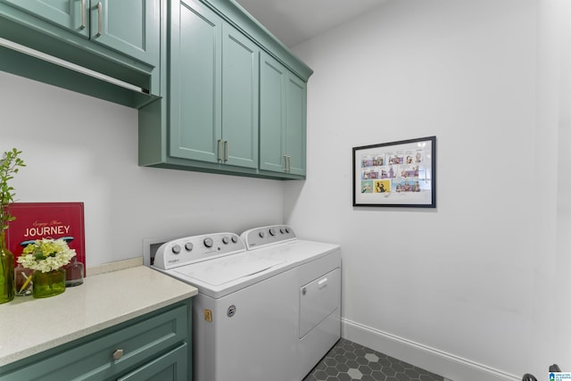 clothes washing area with cabinets and washing machine and clothes dryer