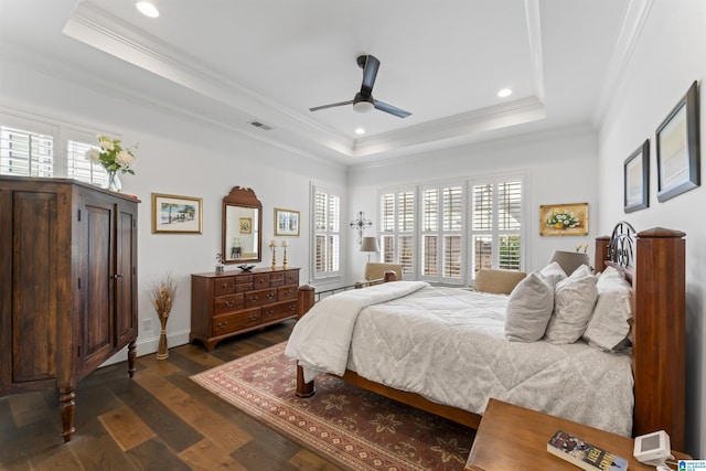 bedroom with a raised ceiling, crown molding, dark hardwood / wood-style floors, and ceiling fan