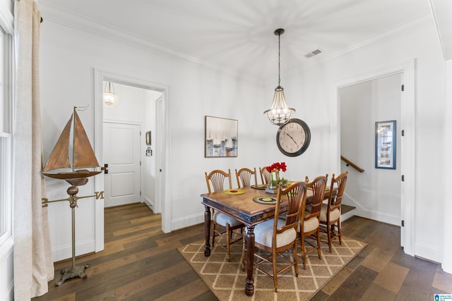 dining area featuring dark wood-type flooring, crown molding, and an inviting chandelier