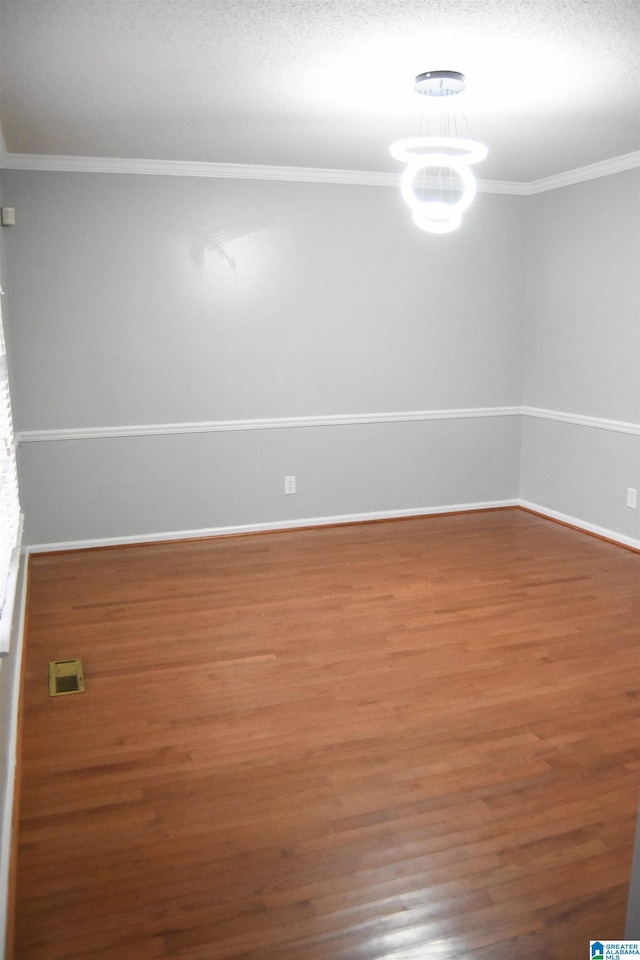 unfurnished room with wood-type flooring and ornamental molding