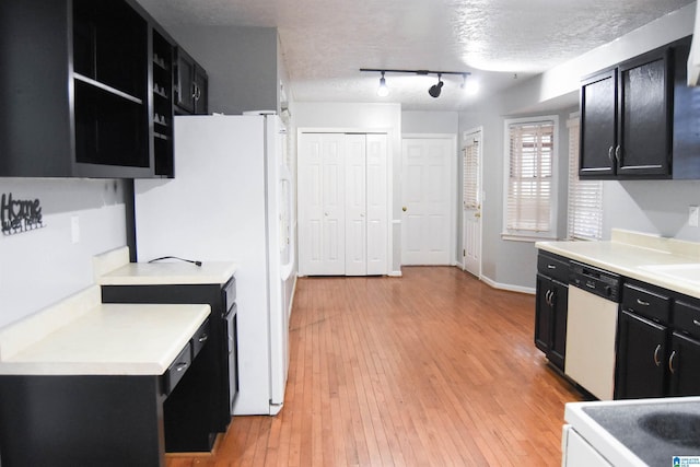 kitchen featuring a textured ceiling, dishwasher, track lighting, white refrigerator, and light wood-type flooring