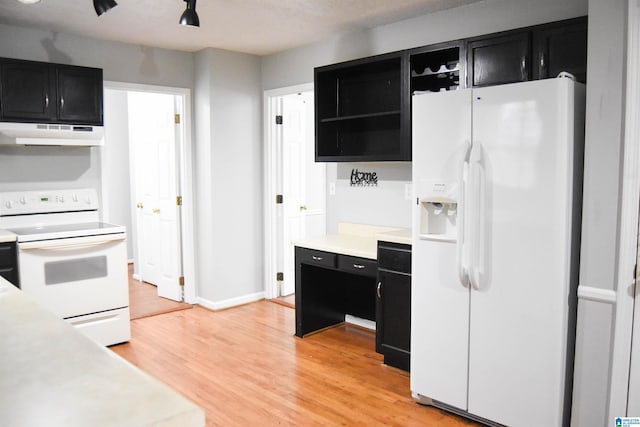 kitchen with white appliances and light hardwood / wood-style flooring