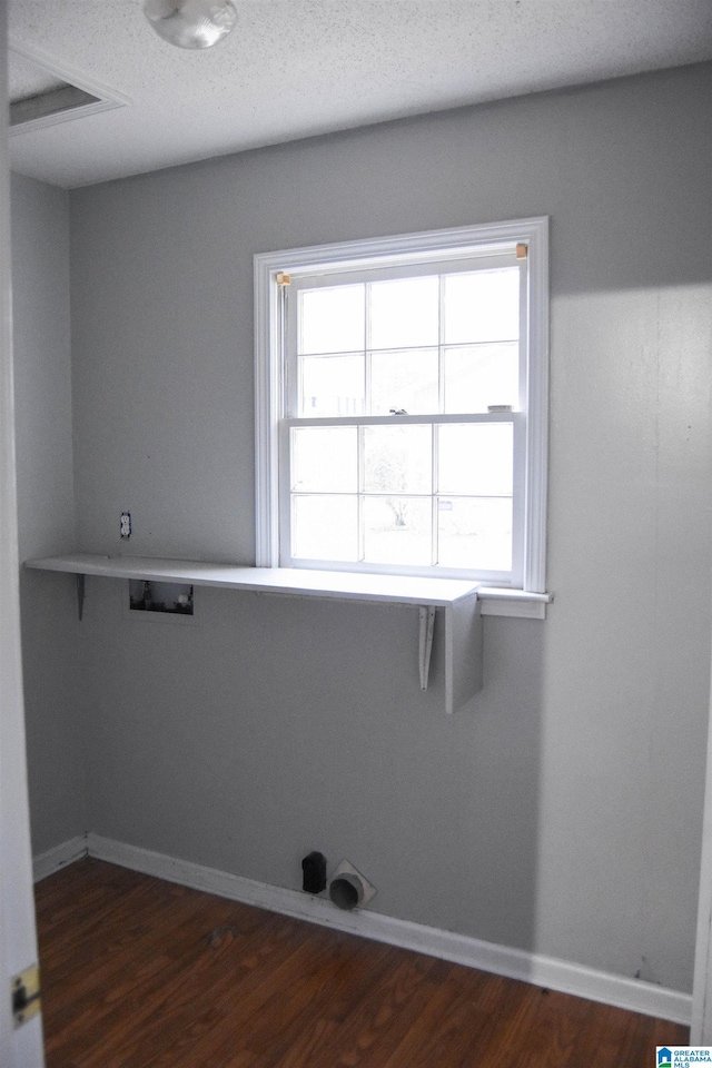 clothes washing area featuring a textured ceiling, dark hardwood / wood-style flooring, and hookup for a washing machine