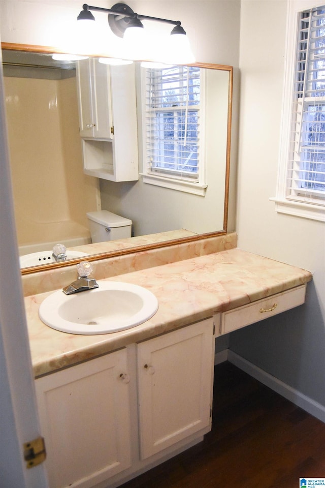 bathroom featuring wood-type flooring, toilet, and vanity