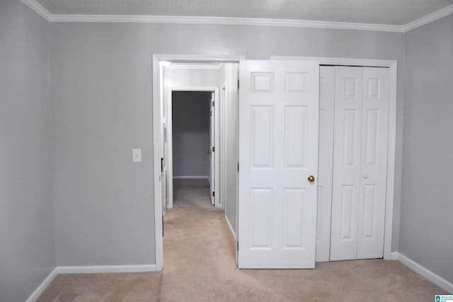 unfurnished bedroom with light carpet, a closet, and crown molding