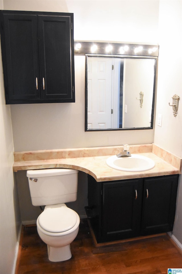 bathroom with toilet, hardwood / wood-style floors, and vanity