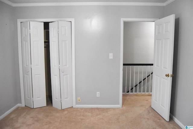 unfurnished bedroom with light colored carpet, a closet, and crown molding