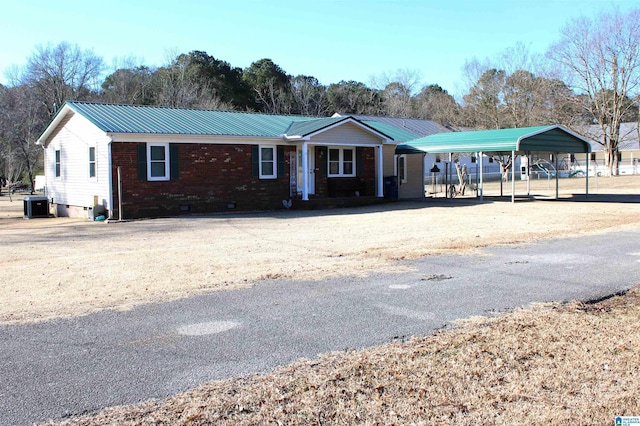 single story home with central air condition unit and a carport