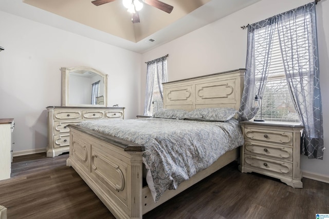 bedroom with ceiling fan, multiple windows, and dark hardwood / wood-style flooring