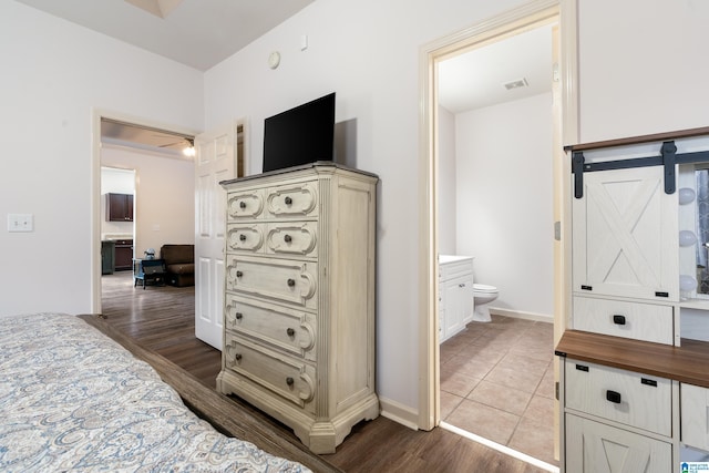 tiled bedroom featuring ensuite bath