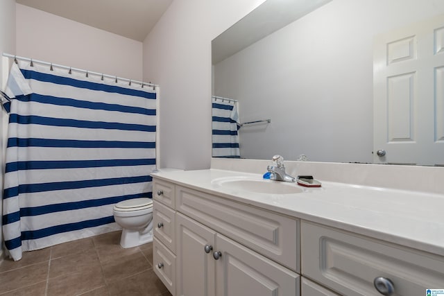 bathroom featuring curtained shower, toilet, vanity, and tile patterned flooring