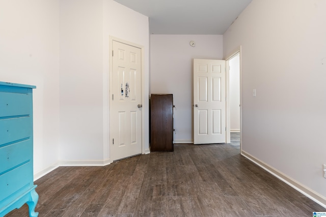 unfurnished room with dark wood-type flooring