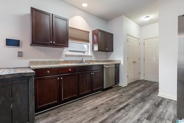 kitchen with sink, hardwood / wood-style flooring, dark brown cabinets, and stainless steel dishwasher