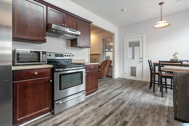 kitchen with dark brown cabinets, dark wood-type flooring, hanging light fixtures, and stainless steel appliances