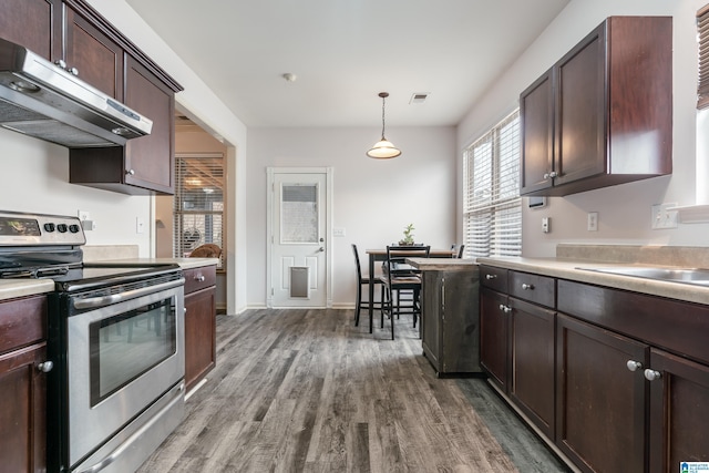 kitchen with stainless steel electric stove, dark brown cabinetry, decorative light fixtures, wood-type flooring, and sink