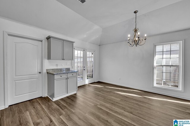 kitchen featuring dark wood-type flooring, hanging light fixtures, a chandelier, vaulted ceiling, and gray cabinetry