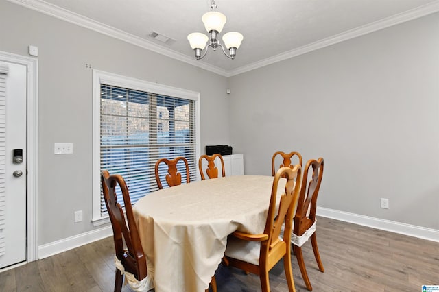 dining space featuring an inviting chandelier, a wealth of natural light, crown molding, and hardwood / wood-style floors