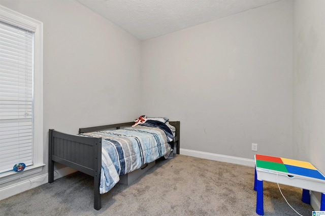 bedroom with a textured ceiling, lofted ceiling, and light colored carpet