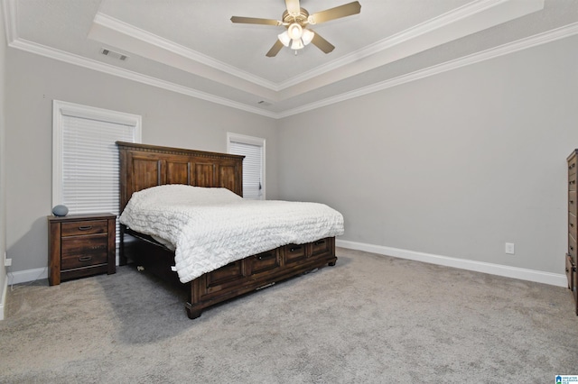 bedroom featuring ceiling fan, light carpet, crown molding, and a tray ceiling