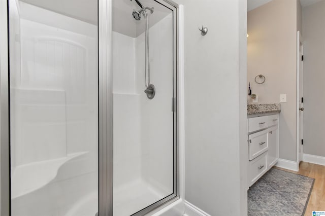 bathroom with vanity, a shower with door, and hardwood / wood-style flooring