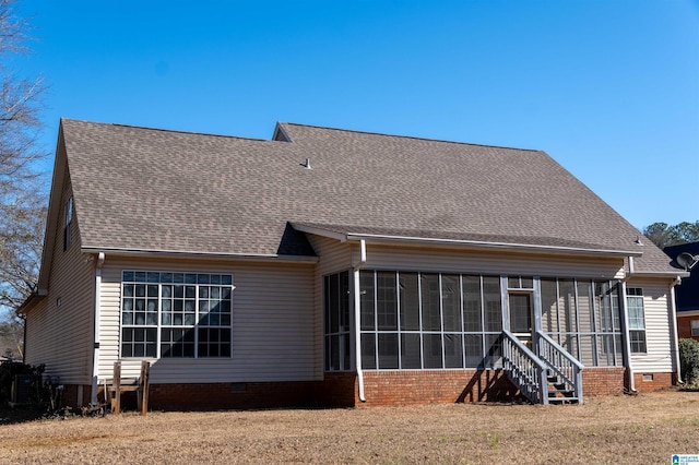 rear view of property with a sunroom and a lawn