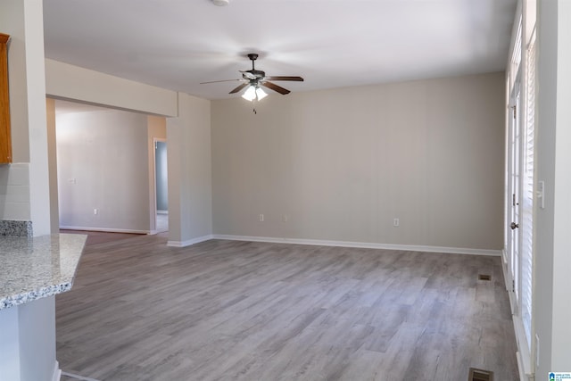 unfurnished living room with ceiling fan and wood-type flooring