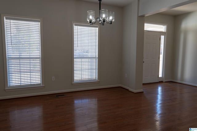 entrance foyer featuring dark hardwood / wood-style flooring and a notable chandelier