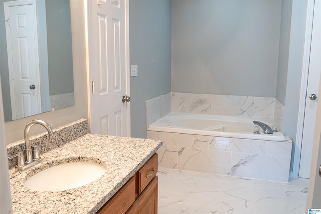 bathroom featuring vanity and a relaxing tiled tub