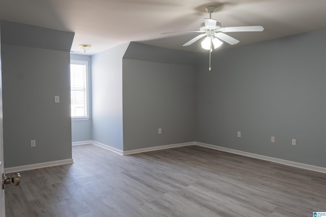 empty room with ceiling fan and light hardwood / wood-style floors