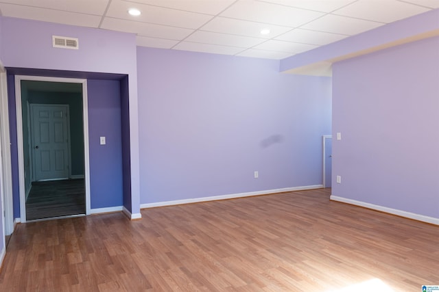 spare room with a drop ceiling and hardwood / wood-style floors