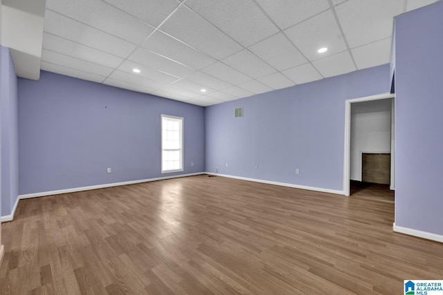 spare room with hardwood / wood-style floors and a paneled ceiling