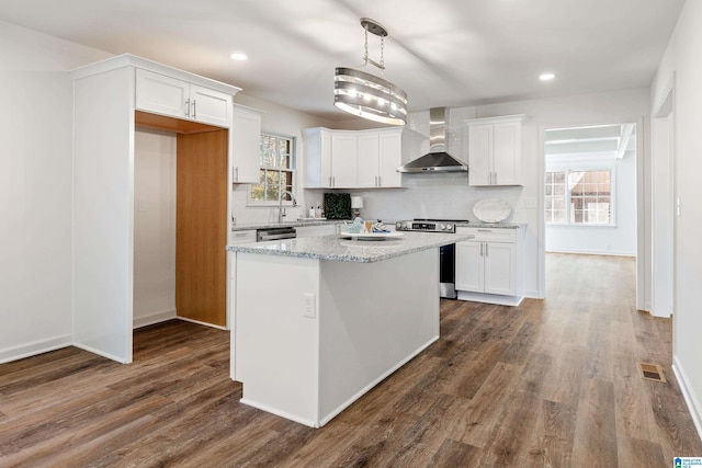 kitchen featuring electric range, white cabinets, wall chimney exhaust hood, and a kitchen island