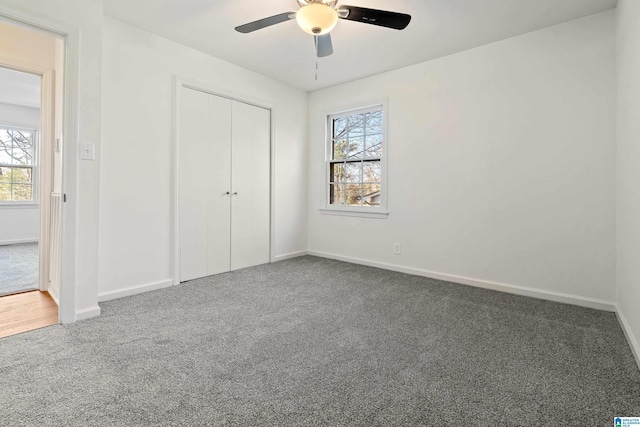 unfurnished bedroom featuring ceiling fan, a closet, and carpet flooring